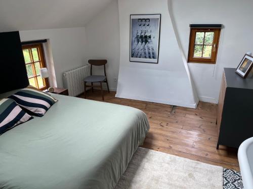 une chambre avec un lit, une table et une chaise dans l'établissement Charmante maison de campagne proche village, à Bonnebosq