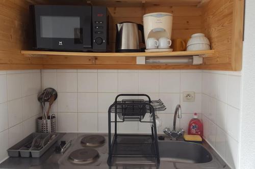 un comptoir de cuisine avec un évier et un micro-ondes dans l'établissement Studio city center, aux Rousses