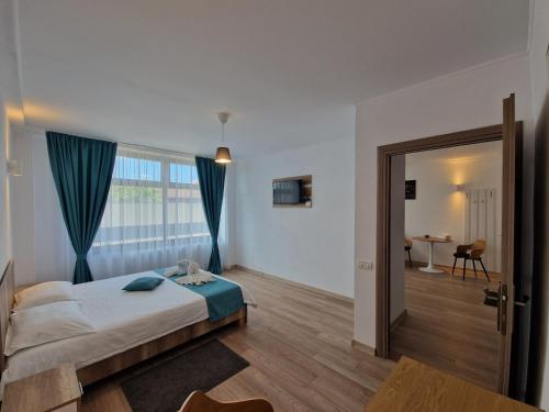 a bedroom with a bed and a room with a table at Casa BID in Piteşti