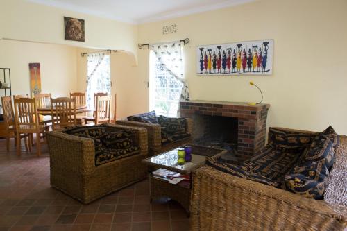 a living room with two couches and a fireplace at Coffee Farm Guest House in Nkoaranga