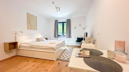ein weißes Schlafzimmer mit einem Bett und einem Tisch in der Unterkunft Ski&Bike Apartmán Blue in Janské Lázně
