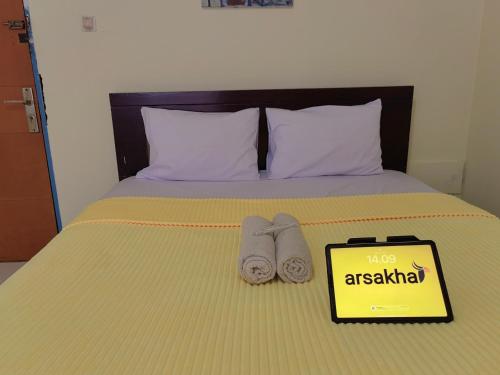 a bed with two towels and a sign on it at Mailbox Arsakha Lobi B Cibubur Village in Cibubur