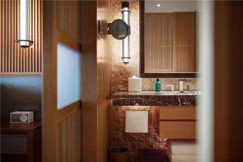 a bathroom with a sink and a mirror at New World Qingyuan Hotel -formerly KHOS QINGYUAN in Qingyuan