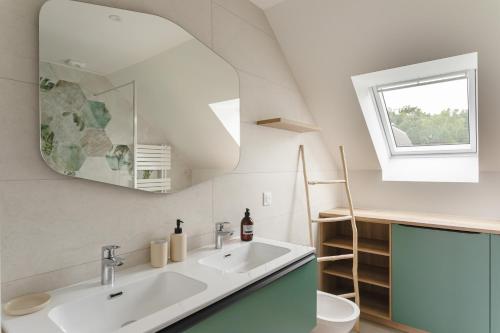 une salle de bain avec un lavabo et un miroir dans l'établissement Ty Fao - Maison pour 10 à Erquy, à Erquy