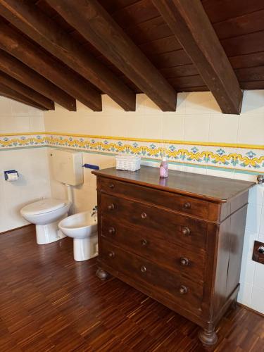 a bathroom with a toilet and a wooden dresser at La Casa di Nina - Traves in Pessinetto