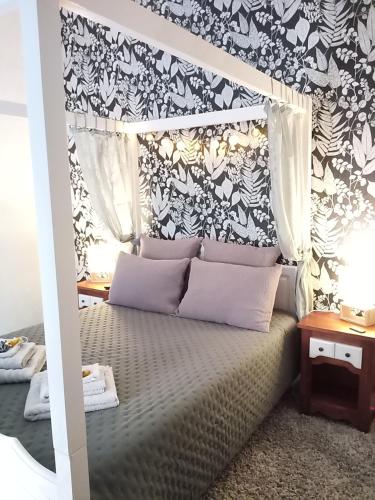 - une chambre avec un lit à baldaquin et du papier peint noir et blanc dans l'établissement Chambre Nounours et Paillette, à Braye-sous-Faye