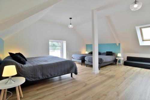 a bedroom with two beds and a couch at Maison récente Le Cellier à Dol-de-Bretagne proche Mont-Saint-Michel in Dol-de-Bretagne