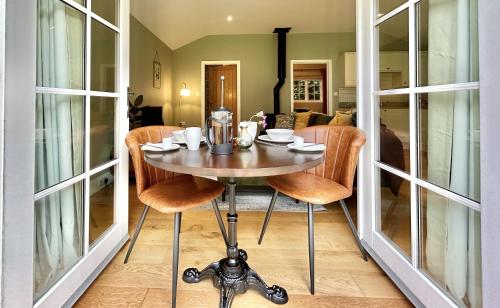 ein Esszimmer mit einem Tisch und einigen Stühlen in der Unterkunft Sancreed House Cottages in Penzance