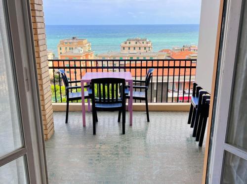 a table and chairs on a balcony with the ocean at Ampio appartamento con vista in Varazze
