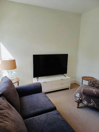 a living room with a couch and a flat screen tv at Stylish 1 Bedroom Flat in Heart of Cowes in Cowes