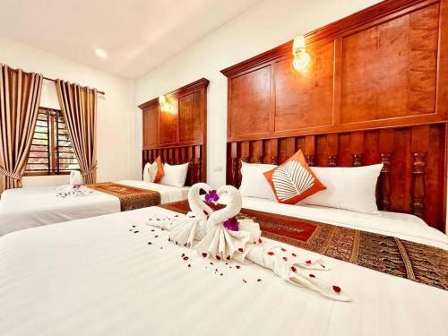 a hotel room with two beds with two swans on them at Pich Mean Bungalow in Sihanoukville