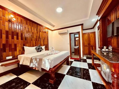 a bedroom with a bed and a black and white checkered floor at Pich Mean Bungalow in Sihanoukville