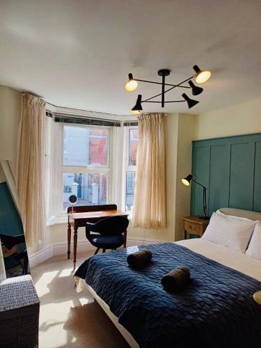 考斯Stylish 1 Bedroom Flat in Heart of Cowes的卧室配有床、书桌和钢琴