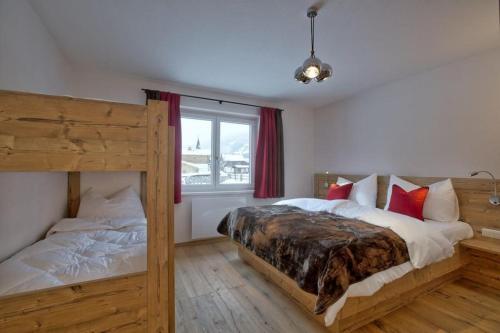 sypialnia z dwoma łóżkami piętrowymi i oknem w obiekcie Chalet Dorfkristall w mieście Bramberg am Wildkogel