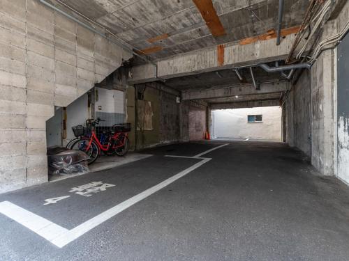 a parking lot with bikes parked in a tunnel at Tabist City Hotel Patio in Takamatsu