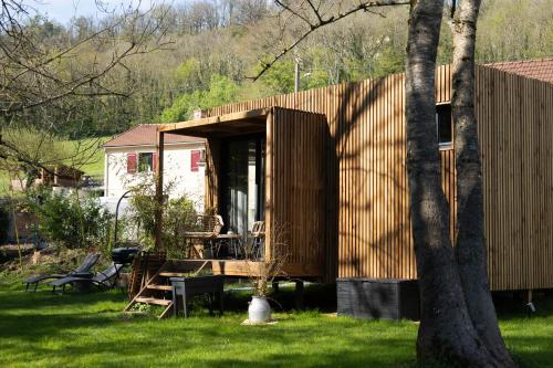 une petite maison en bois dans une cour avec un arbre dans l'établissement La Casa du Vau, à Bussy-le-Grand