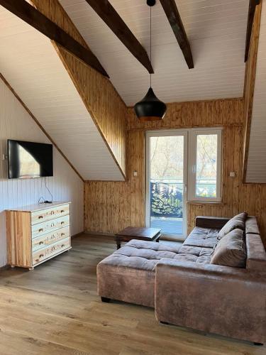a large living room with a couch and a television at Gnapówka in Zawoja