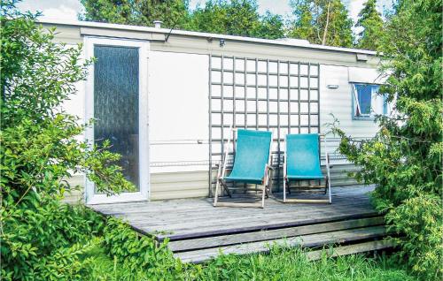 two blue chairs sitting on a wooden deck at 2 Bedroom Nice Stacaravan In Darlowo in Darłowo