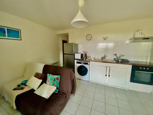 un salon avec un canapé et une cuisine dans l'établissement Appartement 6 personnes, à La Londe-les-Maures
