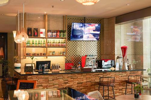 a bar in a restaurant with a tv on the wall at Swiss-Belhotel Bogor in Bogor