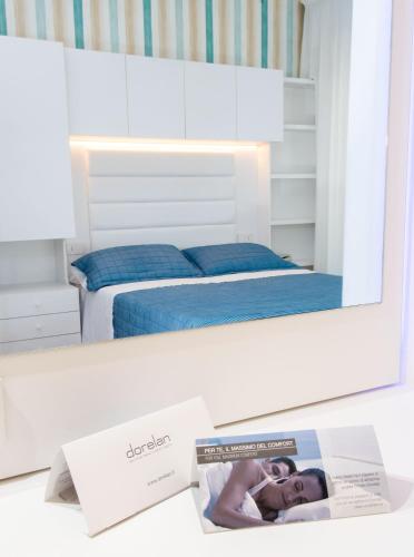 a mirror on a desk with a bed in a bedroom at Hotel Albatros in Misano Adriatico