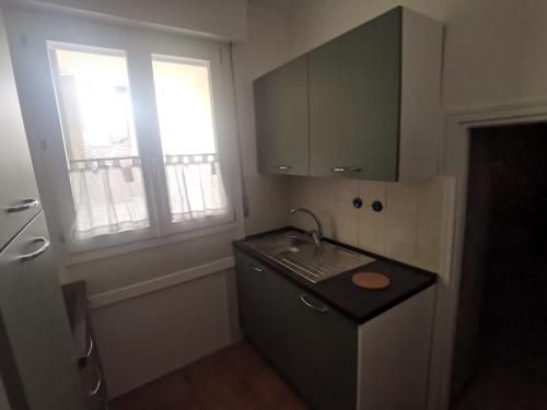 a small kitchen with a sink and a window at Casa del barbiere in Dogliani