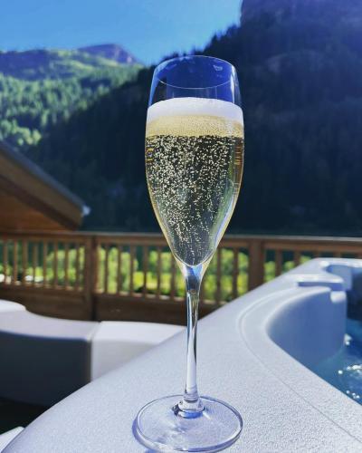 - un verre de champagne assis sur une table à côté d'une baignoire dans l'établissement Luxurious penthouse with private spa- Cap Crystal Lodge, à Tignes