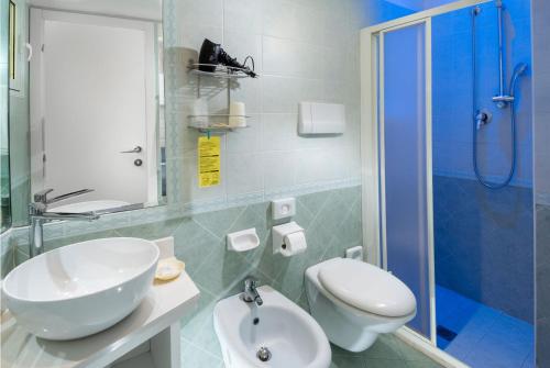 a bathroom with a sink and a toilet and a shower at Hotel Albatros in Misano Adriatico