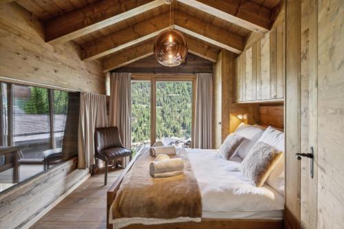 a bedroom with a large bed and a window at Chalet Ksara by Mrs Miggins in Grimentz