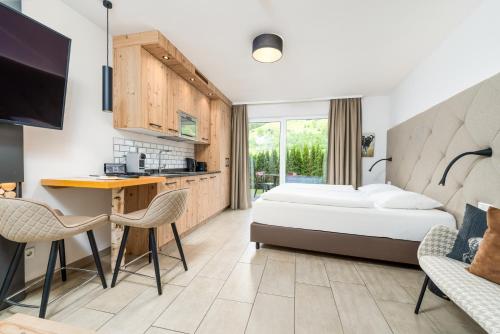 a hotel room with a bed and a desk at AvenidA Panorama Suites in Kaprun