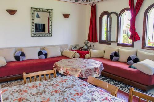 a living room with red couches and a table at Charmant appartement au bord de mer in El Jadida