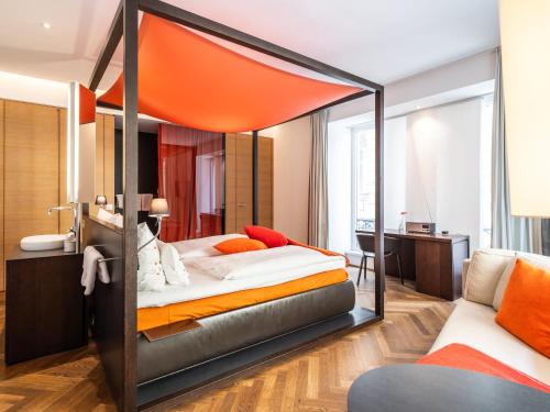 a bedroom with a large bed with an orange canopy at Buxbaum Beletage Design & Boutique Hotel in Vienna