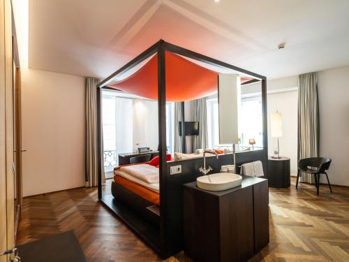 a bedroom with a canopy bed with a sink at Buxbaum Beletage Design & Boutique Hotel in Vienna