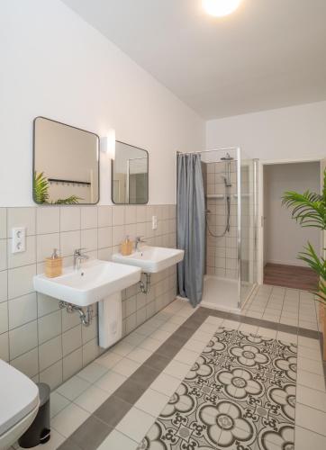 a bathroom with two sinks and a shower at Arbio Monteurzimmer Fredersdorf parking included in Altlandsberg-Süd