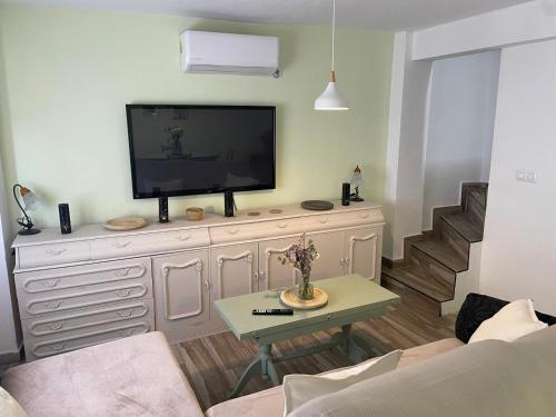 カソルラにあるEl 10 de Solar Bajoのリビングルーム(ドレッサーの上にテレビ付)