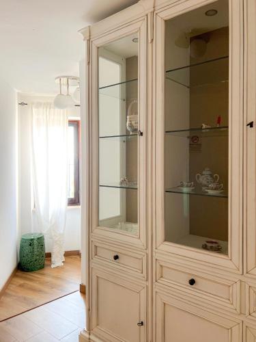 a large wooden cabinet with glass doors in a room at ComeCasa Langhe Garden House-Pace e Panorama a Benevello in Benevello