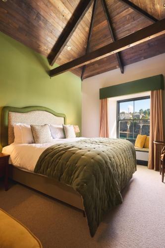 a bedroom with a large bed in a room with a window at Pier House in St Austell