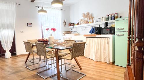 a kitchen with a table with chairs and a refrigerator at ComeCasa Langhe Garden House-Pace e Panorama a Benevello in Benevello