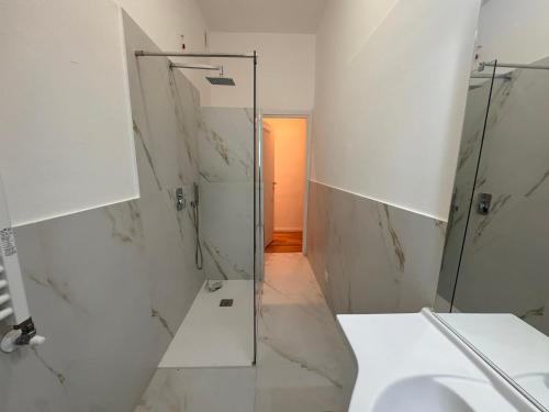 a white bathroom with a shower and a sink at Casa Rosy Como Historic Centre in Como