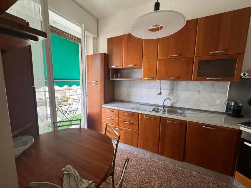 a kitchen with wooden cabinets and a wooden table at Casa Rosy Como Historic Centre in Como