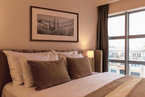 a bedroom with a bed with a large window at Hotel Sirius in Pristina