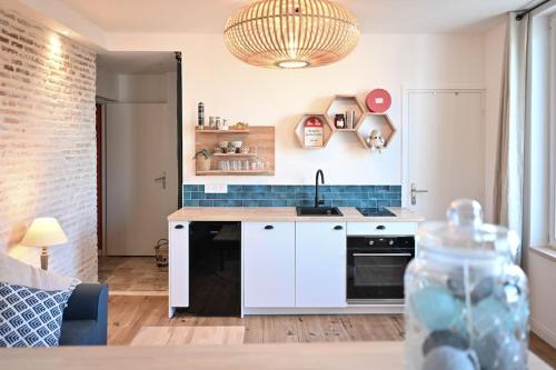 une cuisine avec un évier et une cuisinière four supérieur dans l'établissement Bel appartement hyper centre, à Angers