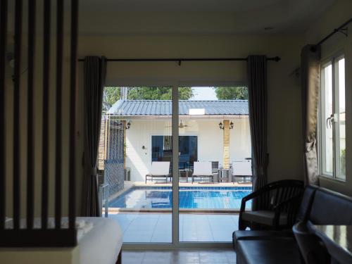 a view of a pool through a sliding glass door at Mangoes Pattaya in Na Jomtien