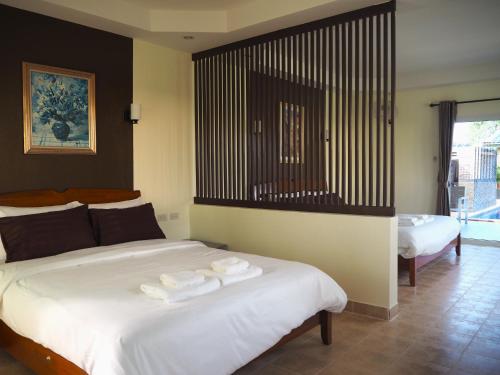 a bedroom with a bed with two towels on it at Mangoes Pattaya in Na Jomtien
