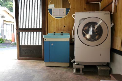 a washer and a washing machine in a room at 海と西一棟貸し宿 in Saitsuno