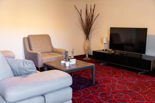 a living room with a couch and a tv at Hotel Sirius in Pristina