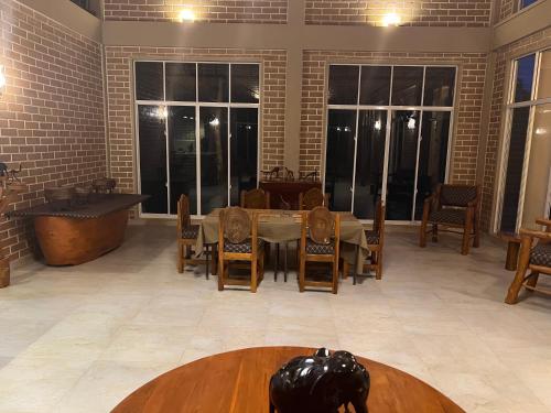 a dining room with a table and chairs and windows at The Sanctuary in Vannativillu