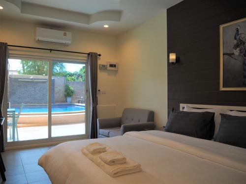a hotel room with a bed and a patio with a pool at Mangoes Pattaya in Na Jomtien