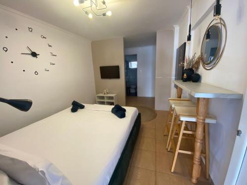 a room with a bed and a clock on the wall at Dims Studio Paralia Ofryniou in Ofrínion