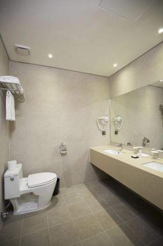 a bathroom with a toilet and a sink and a mirror at Best Western Haeundae Hotel in Busan